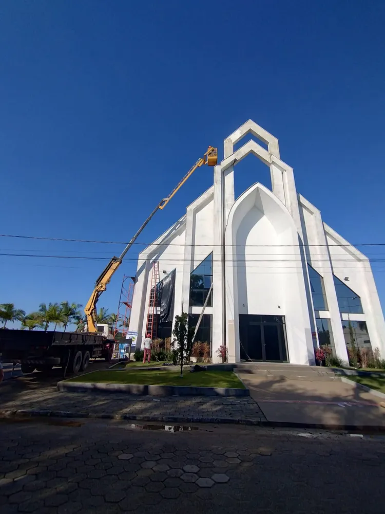 Munck com cesto aéreo em serviço na fachada de uma igreja